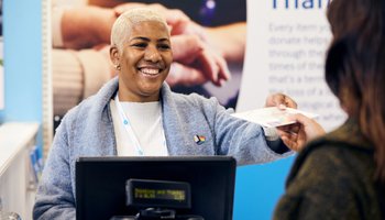 img-hero-retail-smiling-volunteer-till