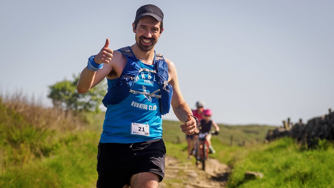 A runner during the Bronte Half Marathon race, smiling and giving the thumbs up