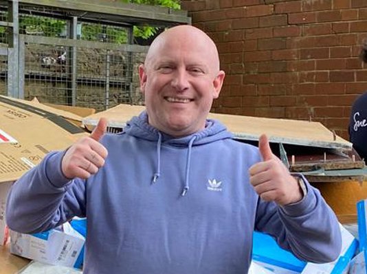 Sue Ryder volunteer, David, giving the double thumbs up