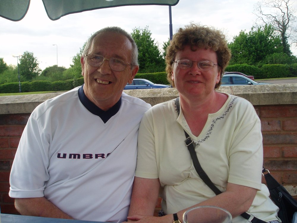 Doug with his arm around Debbie. They are smiling toward the camera.