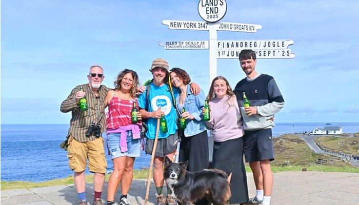 Finley posing with friends and his dog Reggie celebrating reaching the Land's End