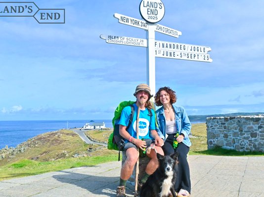 Finley posing with Lauren and his dog Reggie celebrating reaching the Land's End