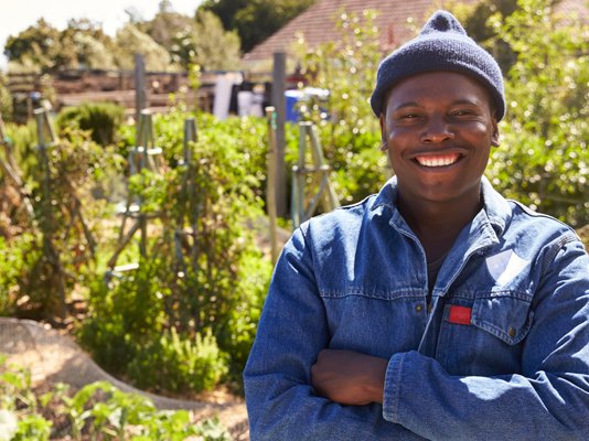 A smiling garden volunteer in an allotment