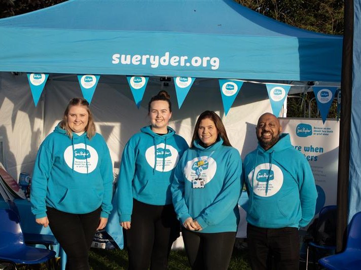 Four members of the Sue Ryder Fundraising team, beneath a Sue Ryder marquee