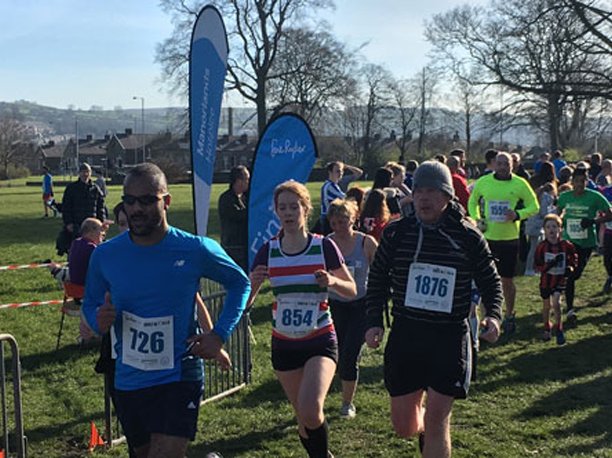 Runners on the Keighley 10k route, with Sue Ryder banners in the background