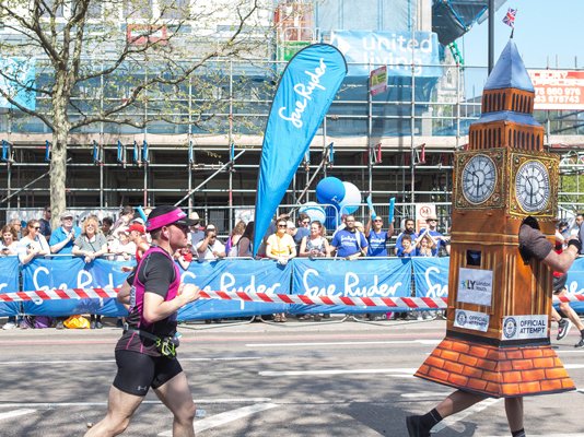 Runners going along the London Landmarks route, with Sue Ryder banners in the background