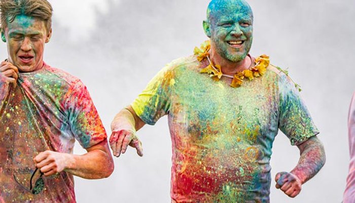 Two runners covered in different coloured paint during the race