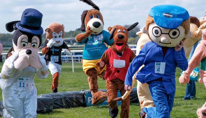 Runners in giant mascot outfits running the race route