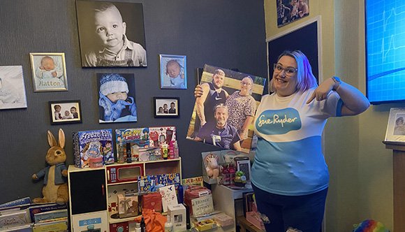 Pippa Tinsley in her Sue Ryder t-shirt surrounded by pictures of her family