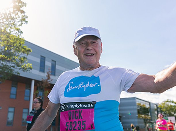 A Sue Ryder runner waving during their race