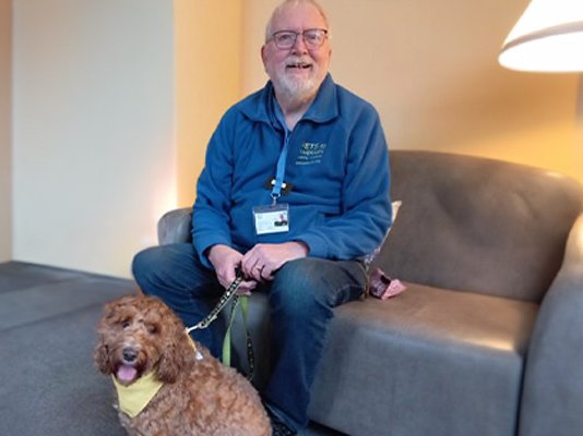 Sue Ryder volunteer, Richard, with Jack the Cockapoo by his side