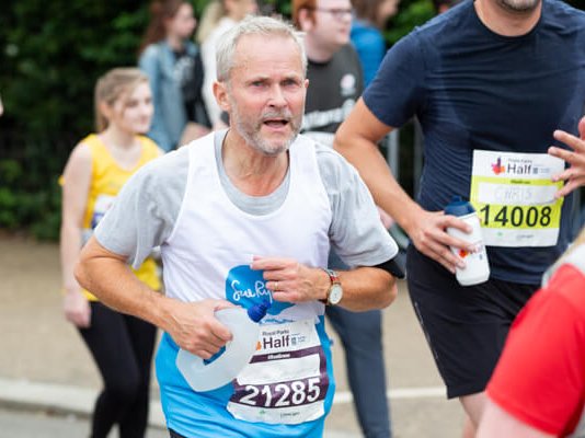 A Sue Ryder runner going along the race route with other runners