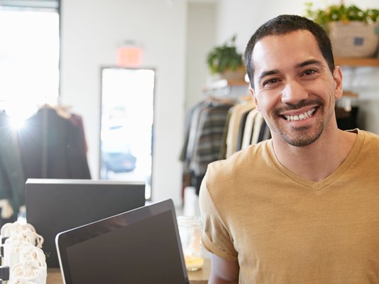 A smiling shop volunteer at the till