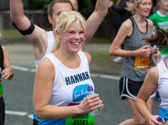 Sue Ryder runners on the Great North Run race route, surrounded by supporters