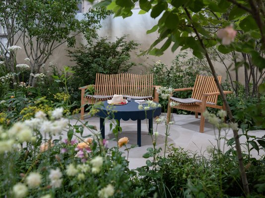 Maria Savoskula's photo of the Sue Ryder Grief Kind Garden, with a table and chairs surrounded by flowers and plants