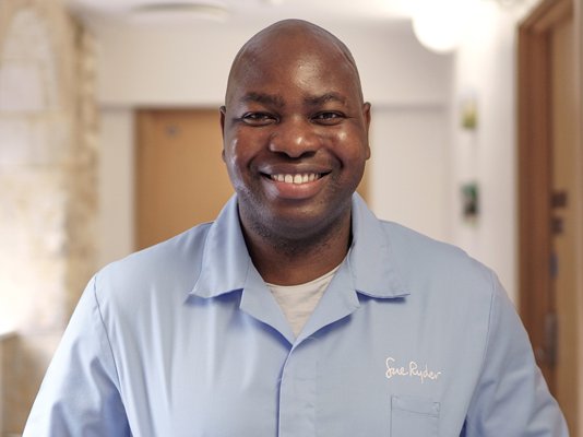 A smiling Sue Ryder Nurse in the hallway of a hospice