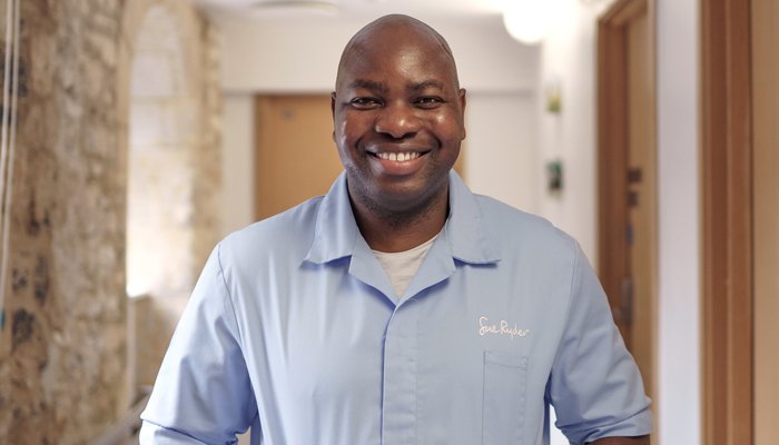 A smiling Sue Ryder Nurse in the hallway of a hospice
