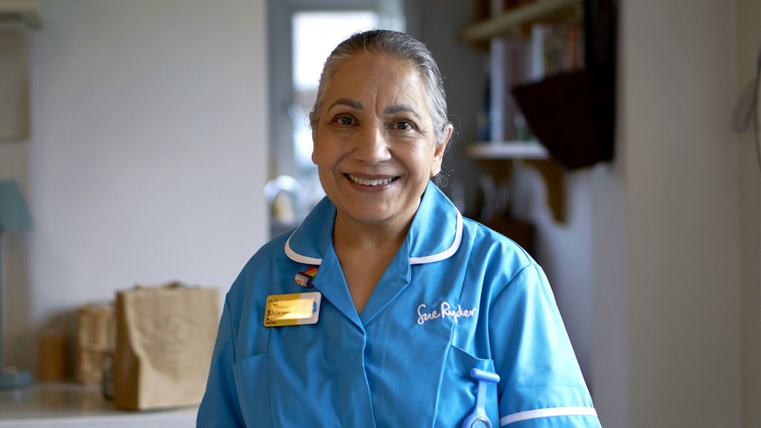 A smiling Sue Ryder Nurse on a hospice at home visit