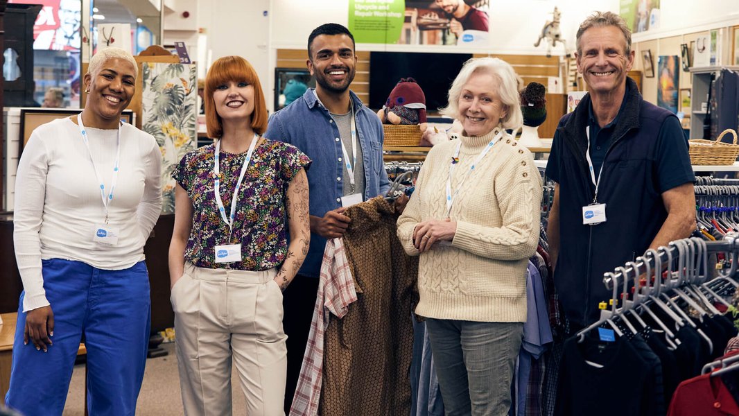 A group of Sue Ryder shop volunteers together on the shop floor