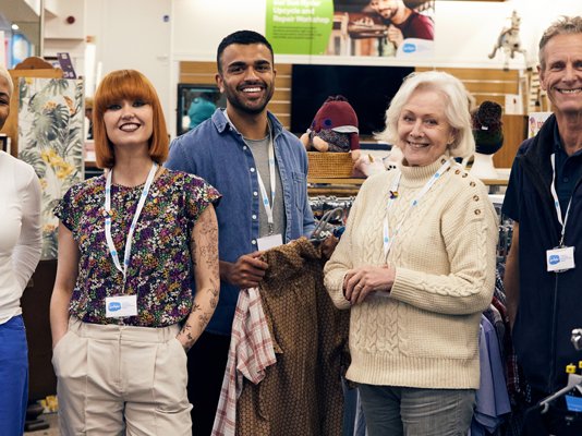 A group of Sue Ryder shop volunteers together on the shop floor