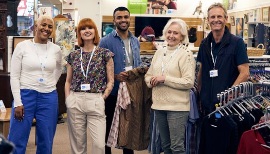 A group of Sue Ryder retail volunteers together on the shop floor