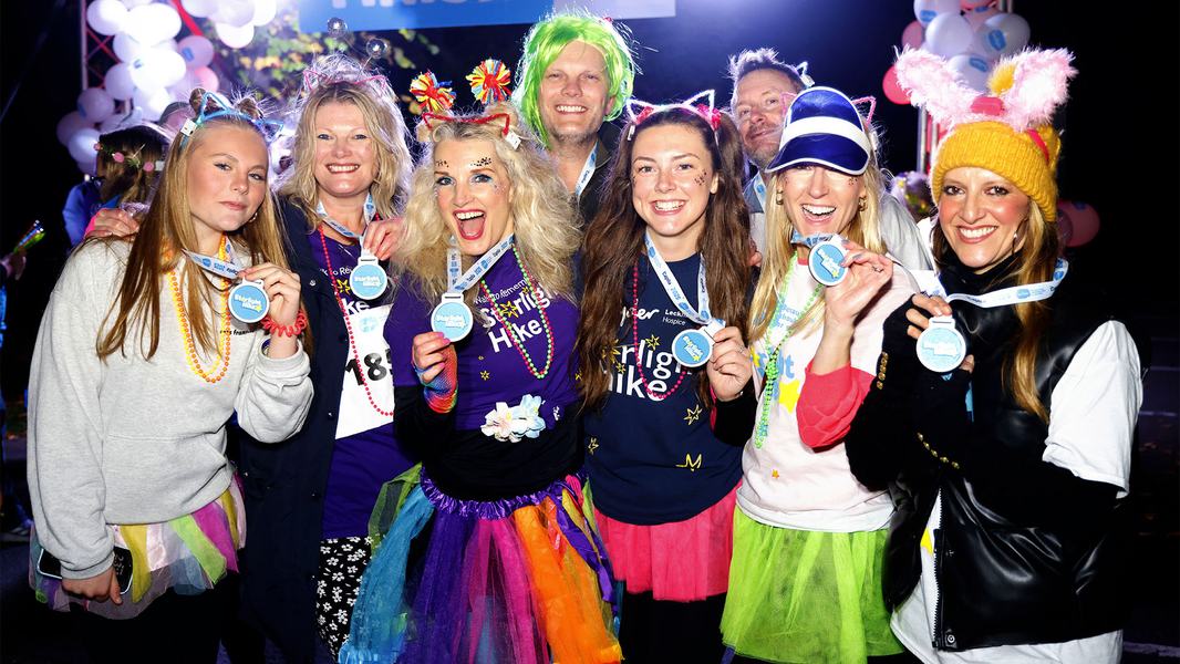 A group of Starlight Hike walkers in bright neon clothing and lights