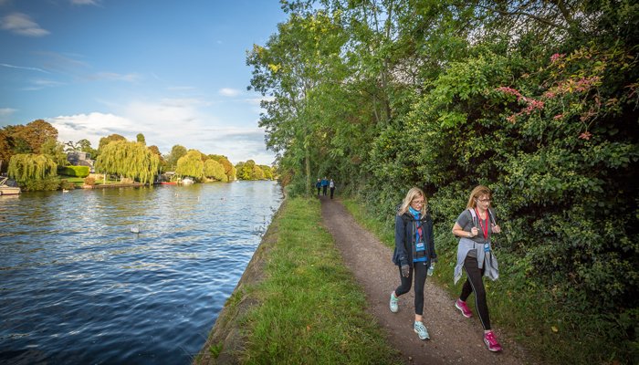 Walkers going along the Thames path route, with the river to their left