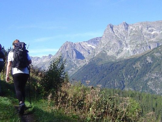 Walkers working their way up Mont Blanc, with snow-covered mountain peaks in the distance