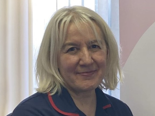 Head and shoulders of Belinda in her dark blue Sue Ryder nurses uniform.