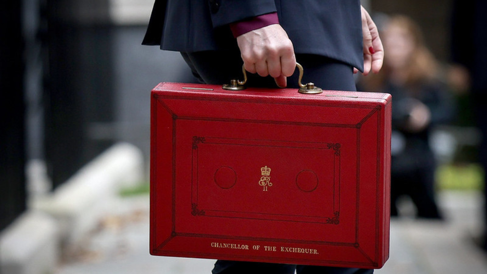 Close up of Rachel Reeves holding red briefcase with Chancellor of the Exchequer written on it in gold.