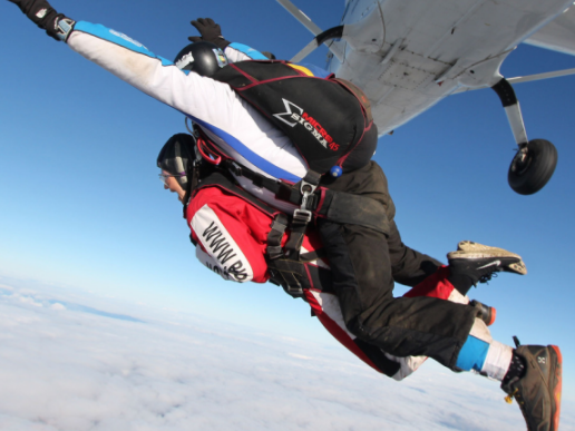 Image of two people jumping out of a plane in a tandem skydive