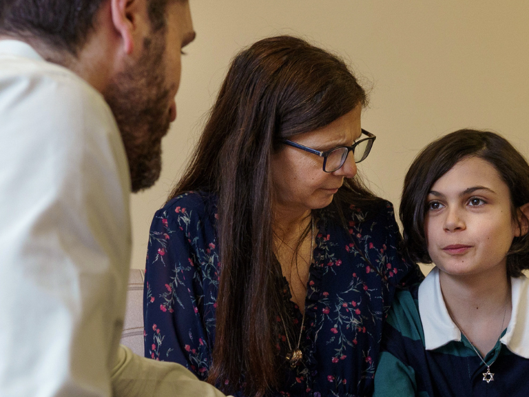 Two adults speaking to a child about bereavement