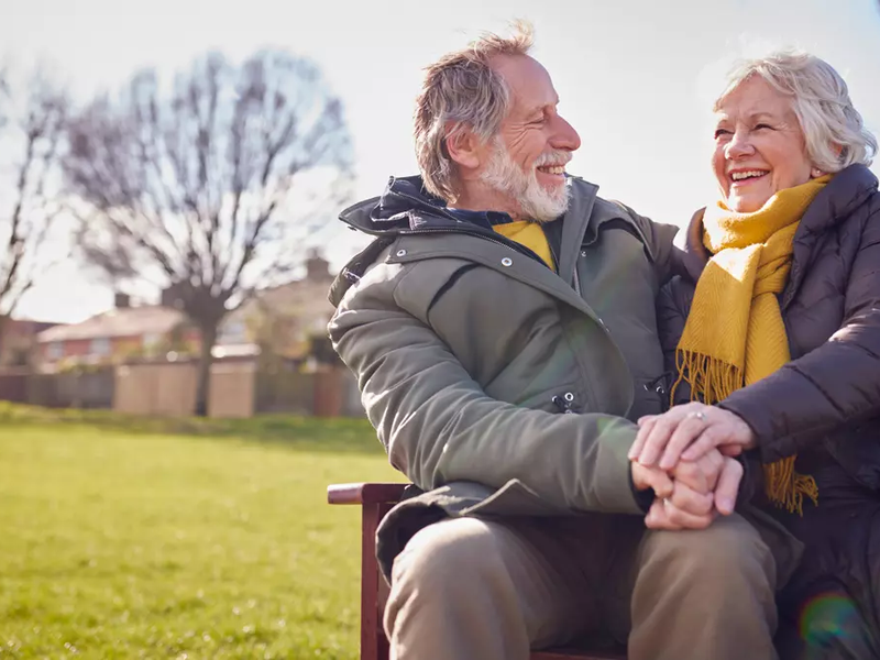 Photo of an older couple holding each other and smiling