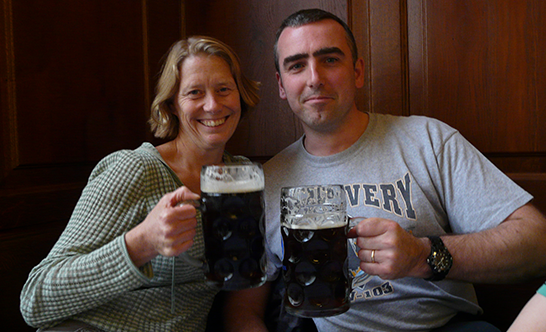 Richard and Heather lift pints of stout and smile into the camera.