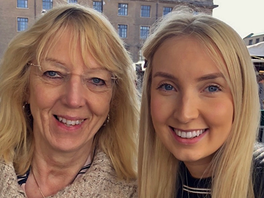 Sophie and her mum smile into camera.